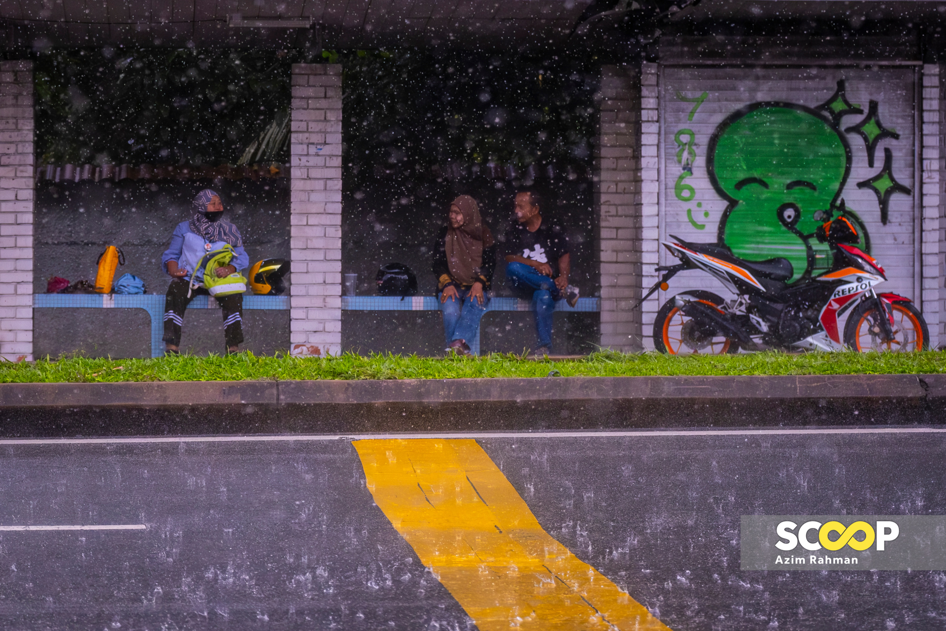Photo of the Day: Motorcyclists caught in rain take cover in Shah Alam